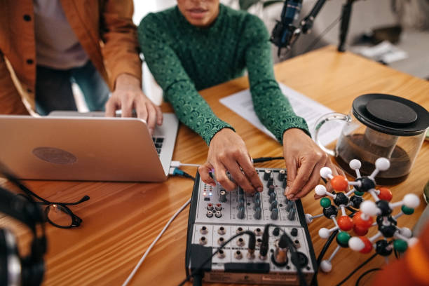 istock Young man and woman editing podcast recording 1355370375