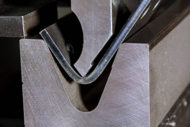 Sheet metal bending on a hydraulic press brake The process of bending sheet metal on a hydraulic bending machine. Metalworking plant. bent stock pictures, royalty-free photos & images