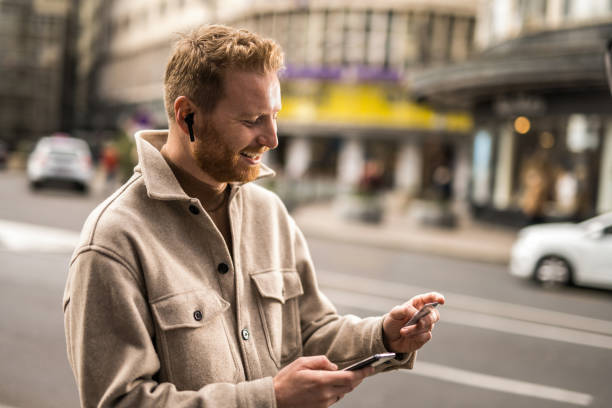 istock Young man using online banking while on a walk on city street. 1355383215