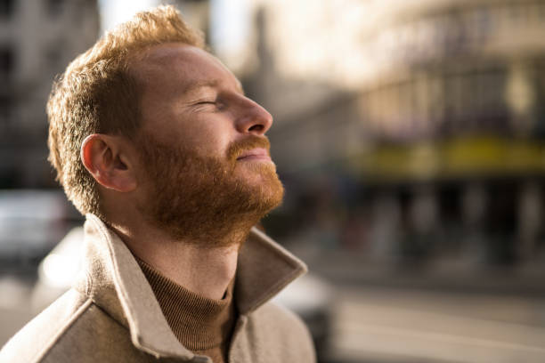 istock Tranquil young man meditating on city street. 1355383264