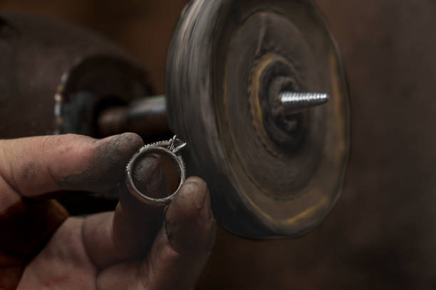 istock Unprotected jeweller's hand using an electric disc to file a silver ring indoors 1355383271