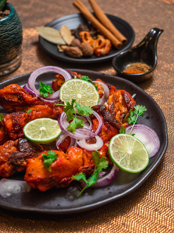 The popular and typical indian food, prepared by roasting chicken marinated in yogurt and spices in a tandoor. Food concept.