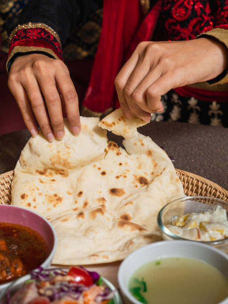 istock Women hand's tering naan bread or roti. 1355388021