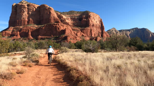 Female mountain biker follows desert track