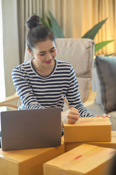 istock Female online store owner pack a shipping boxes for delivery. 1355399087