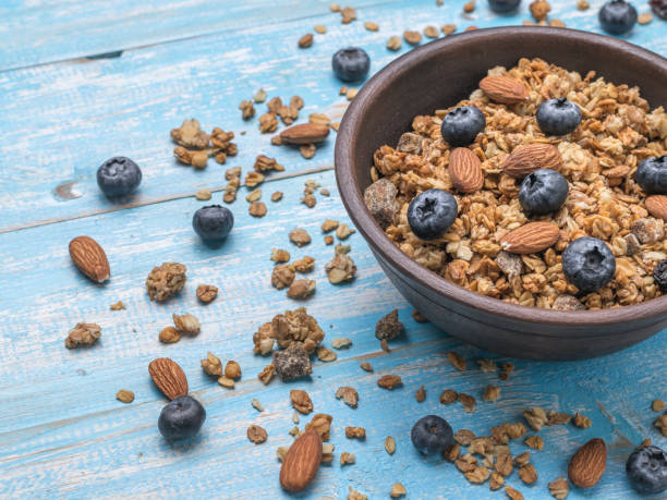istock A deep clay bowl with nuts, berries and muesli on a blue table. 1355400923