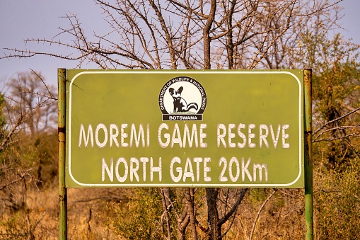 Moremi Game Reserve, Botswana - September 30, 2014. A road sign for the north gate entrance and exit of the wildife park. The background vegetation is bare and dry.