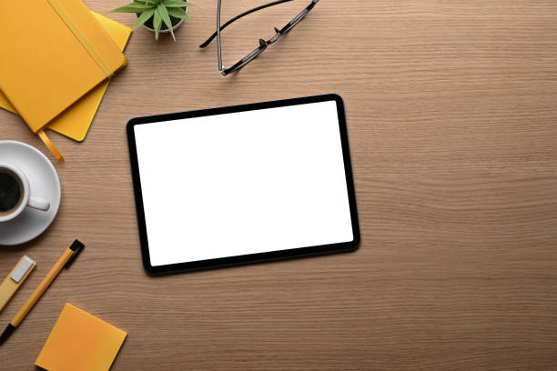 istock Top view mock up digial tablet, coffee cup and stationery on wooden table. 1355419991