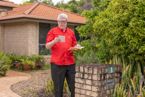 シニアマンは、メールのために彼のレターボックスをチェックします - mail mailbox senior adult cheerful ストックフォトと画像