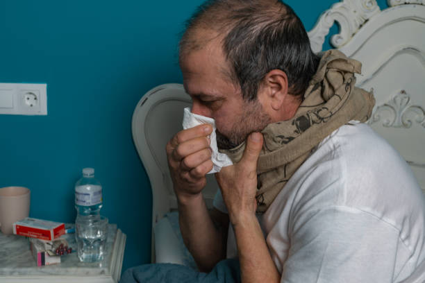 istock sick man in bed with fever 1355422036