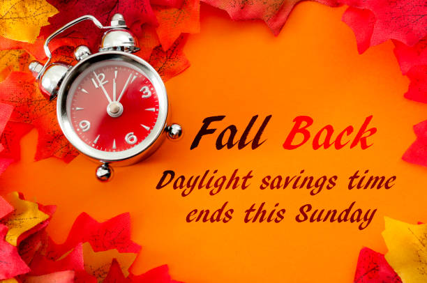 istock Fall back, the end of daylight savings time and turn clocks back on hour concept with a clock surrounded by dried yellow leaves with the text Fall back, daylight savings time ends this Sunday 1355424347