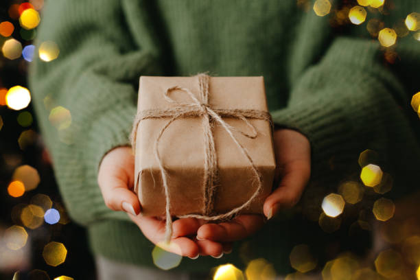 istock Female hands holding nice gift box, blured bokeh light on background. 1355426997