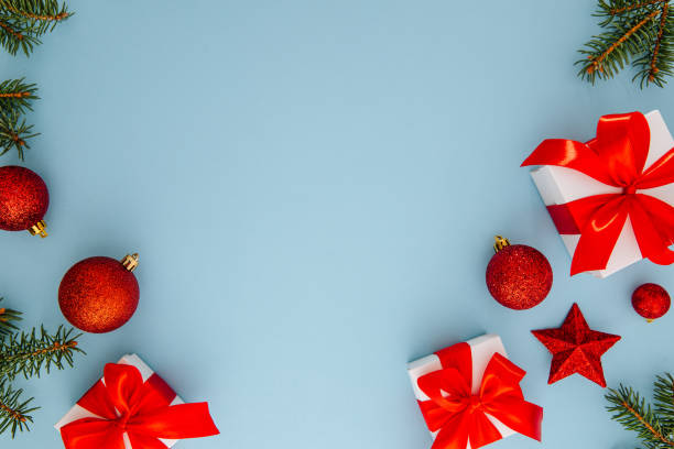 istock Christmas composition, gifts, fir tree branches, red decorations on blue background, winter, new year concept, flat lay, copy space 1355427261