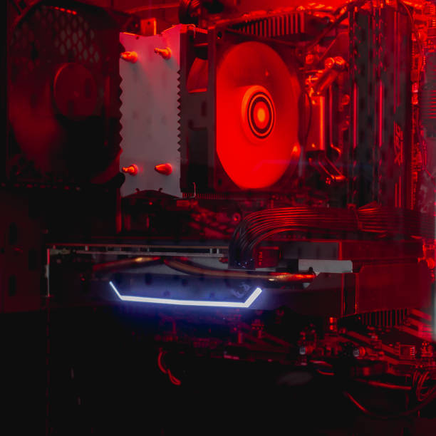 istock Internal parts of the computer system unit: cooler, hard disk, motherboard, video card in red backlight 1355433148