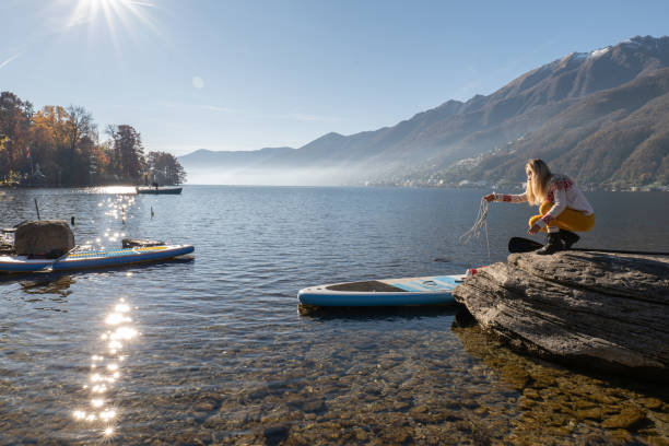istock Young woman docking a stand up paddle on a rock 1355433184