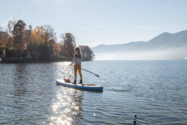 istock Woman paddling on a stand up paddle board 1355433213
