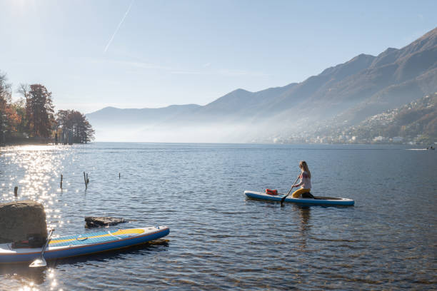 istock Woman paddling on a stand up paddle board 1355433521