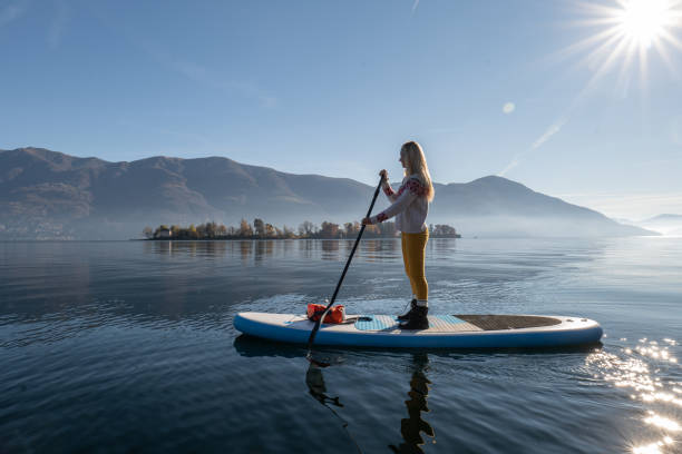istock Woman paddling on a stand up paddle board 1355433544