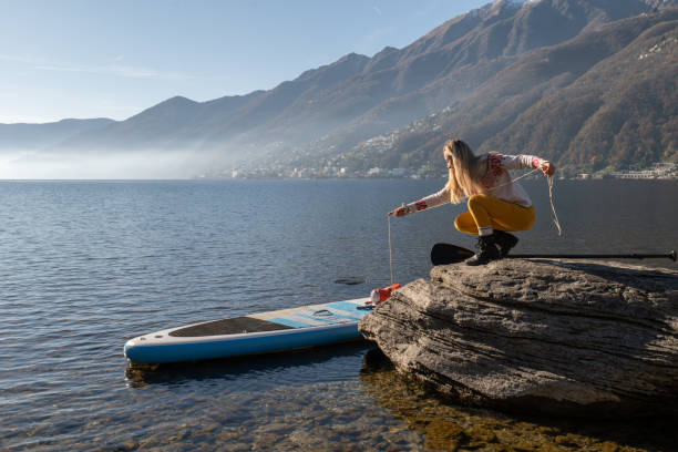 istock Young woman docking a stand up paddle on a rock 1355433545