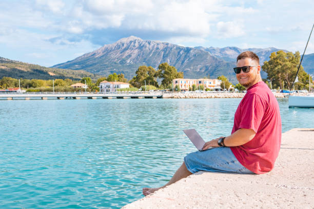 istock man freelancer working on laptop at city harbor bench 1355434290