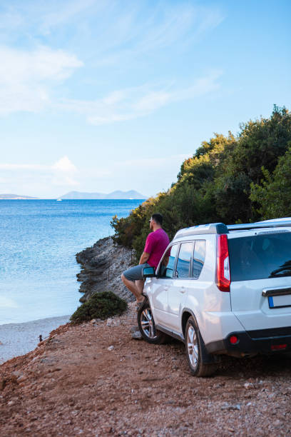 istock man with suv car at sea beach road trip 1355434332