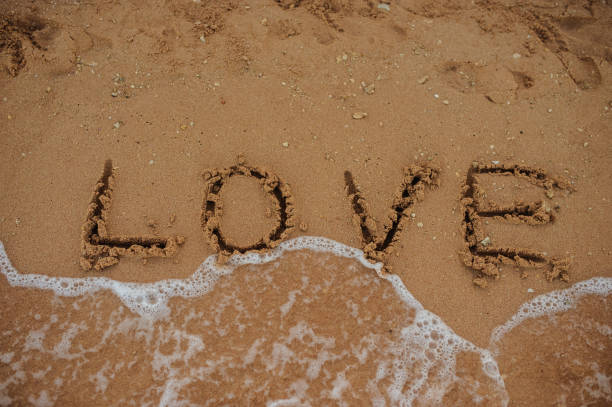 istock LOVE lettering on the beach with wave and sunlight 1355434416
