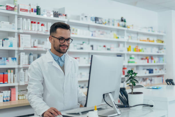retrato de un apuesto farmacéutico que trabaja en una farmacia - pharmacist pharmacy pill medicine fotografías e imágenes de stock