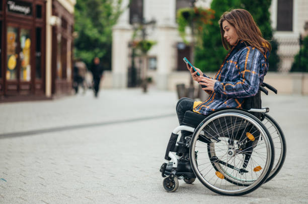 istock Woman with disability using a smartphone while out in the city 1355434750