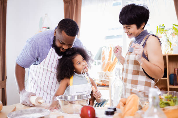istock Happy African American father and daughter having fun while preparing cookie dough at home. happy family time. 1355436912