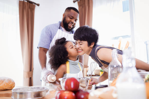 istock Happy African American father and daughter having fun while preparing cookie dough at home. happy family time. 1355437027