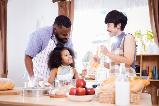istock Happy African American father and daughter having fun while preparing cookie dough at home. happy family time. 1355437066