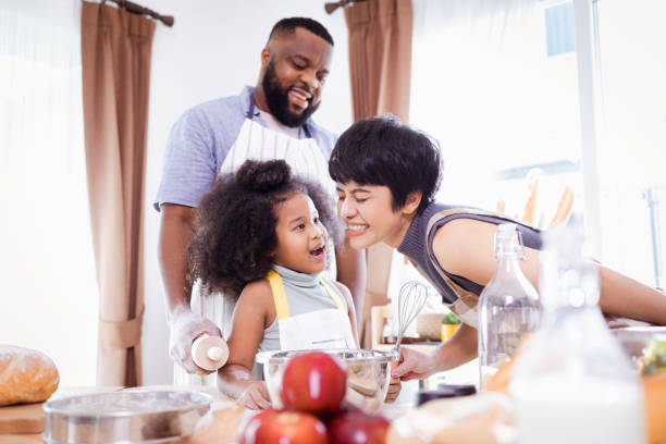 istock Happy African American father and daughter having fun while preparing cookie dough at home. happy family time. 1355437077