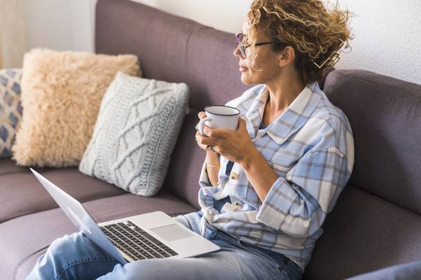 istock Midsection Of Man Using Mobile Phone While Sitting On Sofa At Home 1355438453