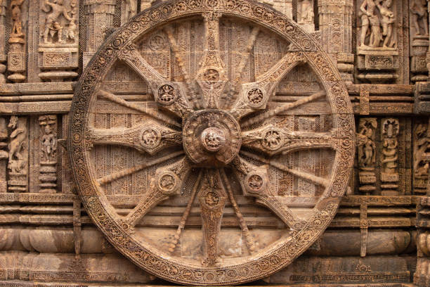 Chariot wheel with eight spokes with a central medallion. The medallions on the wheel spokes are richly carved depicting numerous deities and erotic and amorous figures in various poses. Konark Sun Temple, Orissa India. 13th Century AD. Chariot wheel with eight spokes with a central medallion. The medallions on the wheel spokes are richly carved depicting numerous deities and erotic and amorous figures in various poses. Konark Sun Temple, Orissa India. 13th Century AD. chariot wheel at konark sun temple india stock pictures, royalty-free photos & images