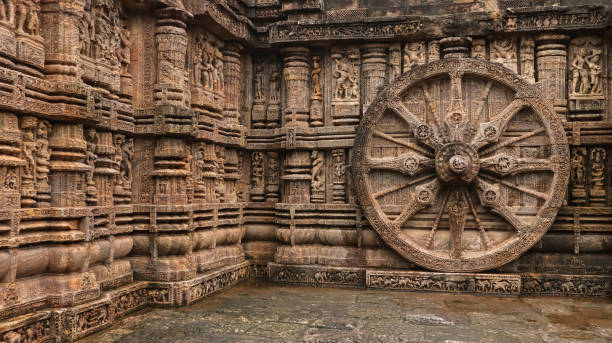 Richly carved Chariot wheel with eight spokes with a central medallion. Deities and erotic and amorous figures shown. Konark Sun Temple, Orissa India Richly carved Chariot wheel with eight spokes with a central medallion. Deities and erotic and amorous figures shown. Konark Sun Temple, Orissa India chariot wheel at konark sun temple india stock pictures, royalty-free photos & images