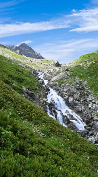 istock waterfall in a mountains by a summer day 1355443696