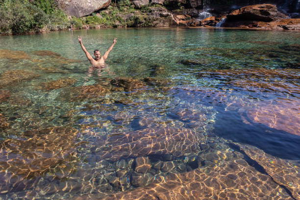 istock young man standing in flowing river clear water at morning from flat angle 1355446868