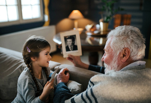 granddad showing her granddaughter memories from past