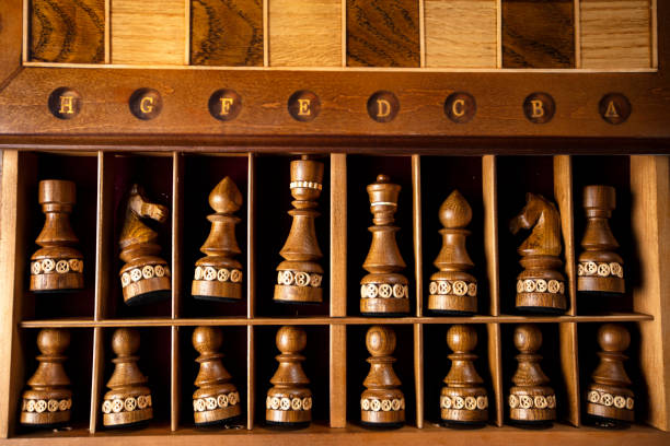 istock Dark chess pieces lie in a box. A puzzle game with tricky combinations that requires planning and thinking. 1355449432