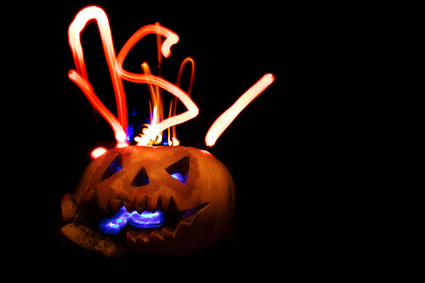 istock Glowing halloween pumpkin on a black background. 1355449466