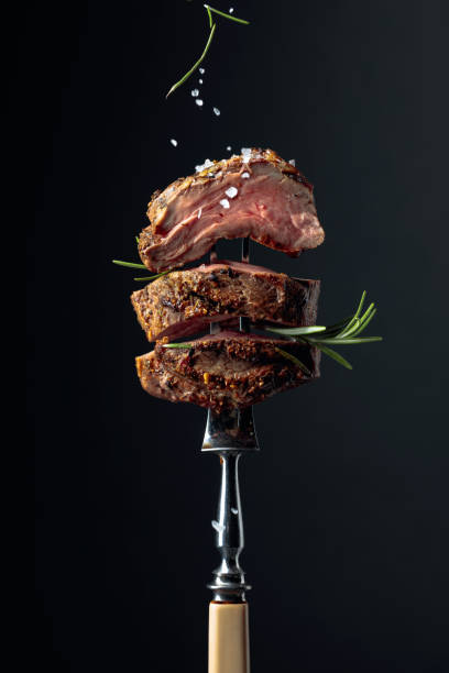 istock Grilled ribeye beef steak with rosemary on a black background. 1355449624