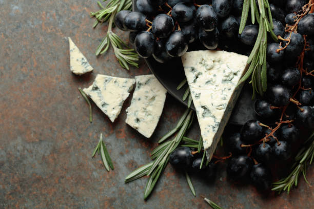 istock Blue cheese with grapes, and rosemary, on vintage background. 1355450217