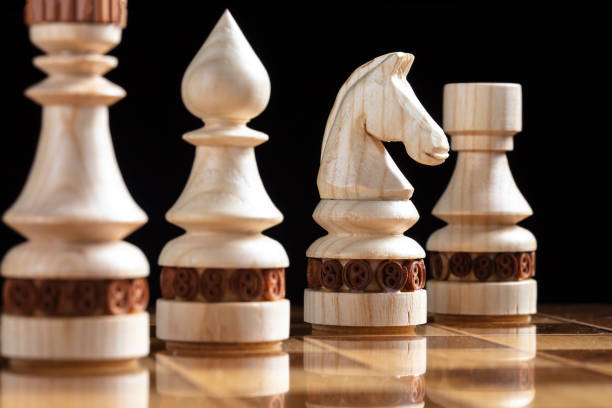 istock White chess pieces on a chess field. A puzzle game with tricky combinations that requires planning and thinking. 1355450235