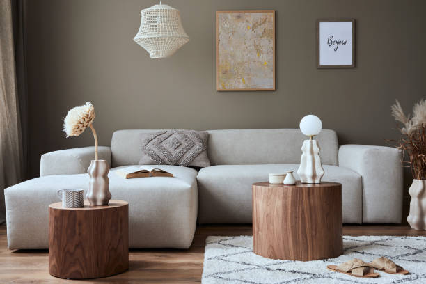 istock Stylish interior of living room with design neutral modular sofa, mock up poster frames, furniture and elegant personal accessories in modern home decor. Template. 1355451802
