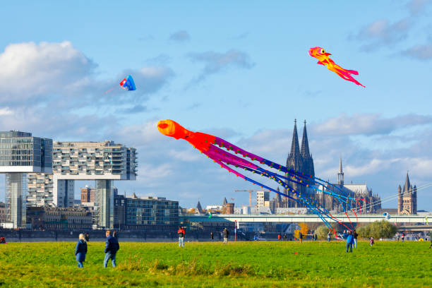Cologne, Germany - November 01, 2021. Colorful holiday hustle and bustle on the Poller Meadow (Poller Wiese) opposite the Rheinau Harbor and Cologne Cathedral on one of the last sunny autumn days of the year.