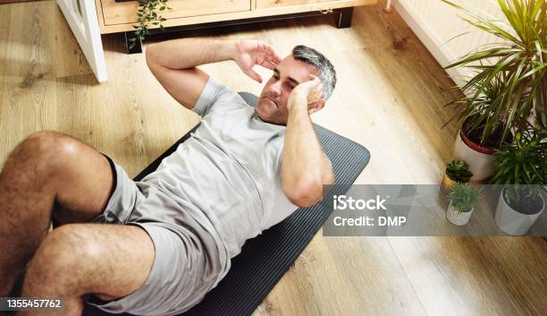 Shot Of A Mature Man Doing Crunches To Strengthen His Core At Home Stock Photo - Download Image Now