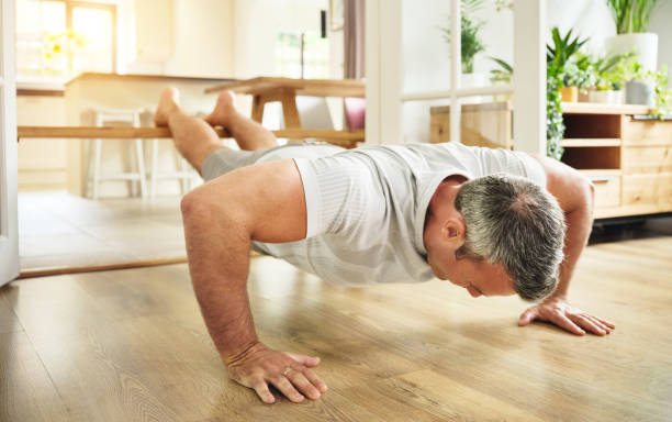 istock Shot of a mature man doing push ups at home 1355457784