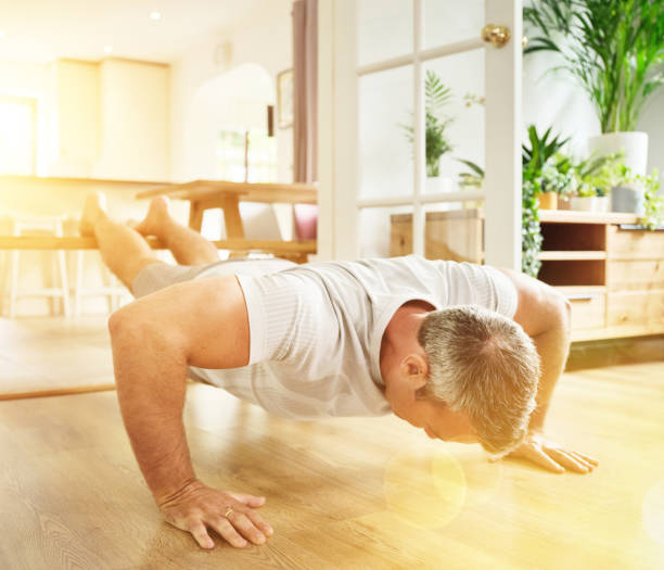 istock Shot of a mature man doing push ups at home 1355457786