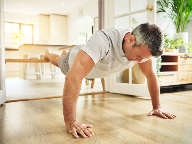istock Shot of a mature man doing push ups at home 1355457825