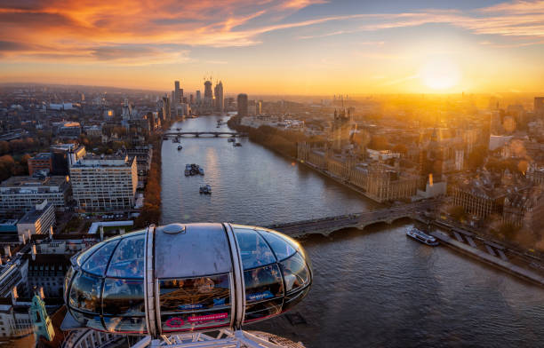 Beautiful sunset view over the city of Westminster from top of the famous London Eye London, UK - November 23rd 2021: beautiful sunset view over the city of Westminster and river Thames from top of the London Eye with a gondola in the foreground and people enjoying the ride central london stock pictures, royalty-free photos & images